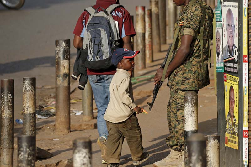 A boy looks at an Ugandan soldier in Kampala, Uganda on February 20, 2016. Photo: Reuters