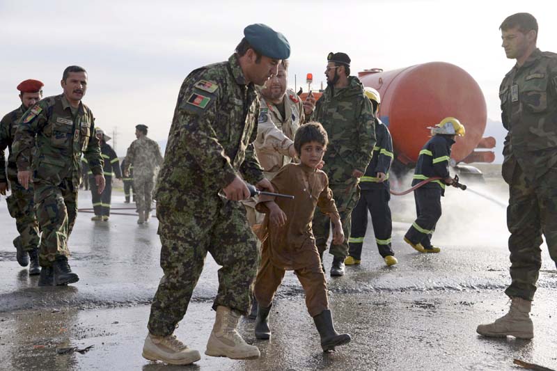 An Afghan National Army officer escorts a slightly injured boy from the site of a suicide attack on the outskirts of Mazar-i-Sharif, Afghanistan on Monday, February 8, 2016. Photo: Reuters