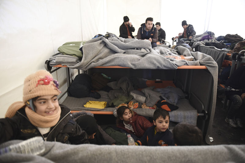Afghan refugees sit inside a tent as they wait to be allowed to continue their journey to Macedonia, at a refugee camp near the northern Greek village of Idomeni, on Saturday, February 6, 2016. Photo: AP