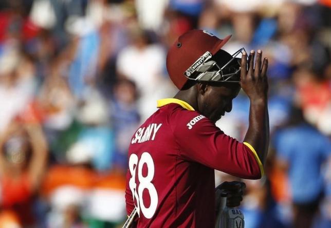 West Indies batsman Darren Sammy walks off the field after being caught behind by India's captain MS Dhoni during their Cricket World Cup match in Perth, March 6, 2015. REUTERS/David Gray