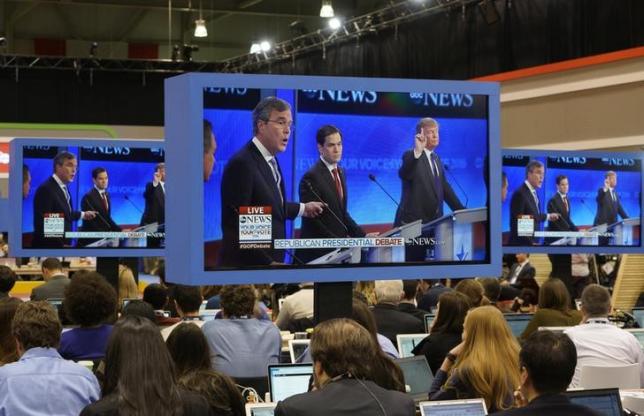 Republican U.S. presidential candidate businessman Donald Trump (R) and former Governor Jeb Bush (L) debate each other as U.S. Senator Marco Rubio (C) stands between the two men as journalists watch the debate on monitors in the media filing center during the Republican U.S. presidential candidates debate sponsored by ABC News at Saint Anselm College in Manchester, New Hampshire February 6, 2016. REUTERS/Rick Wilking