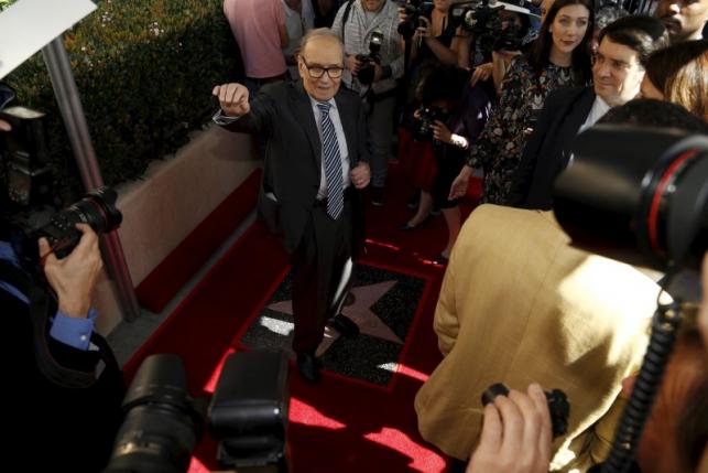 Italian composer Ennio Morricone poses on his star after it was unveiled on the Hollywood Walk of Fame in Hollywood, California February 26, 2016.   REUTERS/Mario Anzuoni