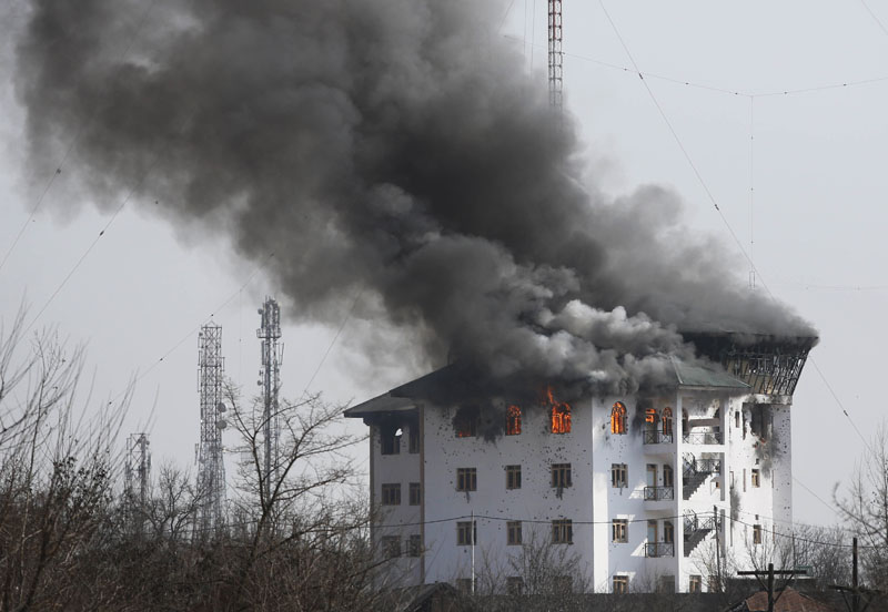 Smoke billows from a building where suspected militants have taken refuge during a gun battle in Pampore, near Srinagar, Indian controlled Kashmir, Indian-controlled Kashmir, on Monday, February 22, 2016. Photo: AP