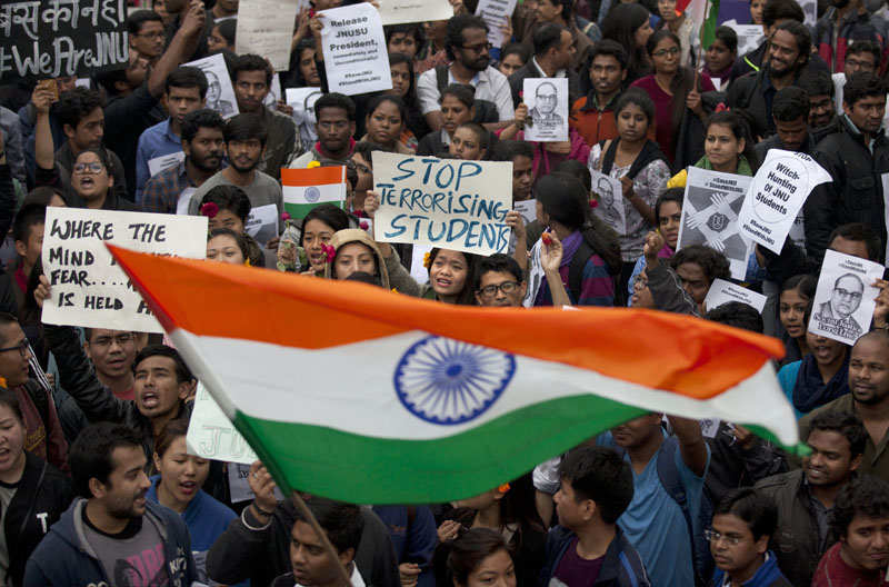 Indian students wave an Indian flag and shout slogans during a protest at the Jawaharlal Nehru University against the arrest of a student union leader in New Delhi, India, on Thursday, February 18, 2016. Photo: AP