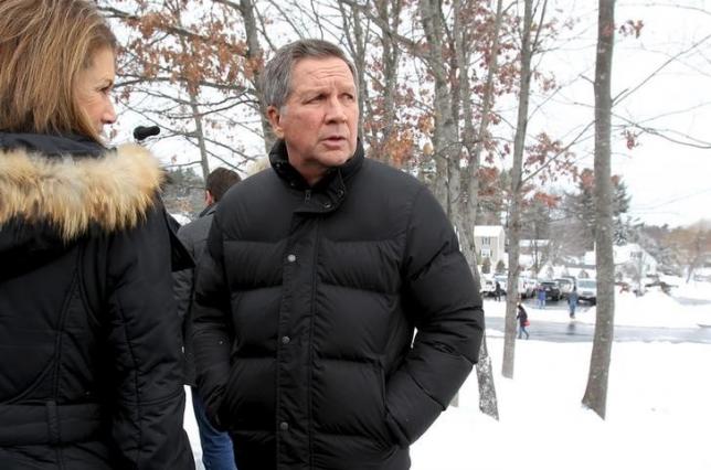 U.S. Republican presidential candidate and Ohio Governor John Kasich talks with his wife Karen outside a polling place at Broad Street Elementary School in Nashua, New Hampshire, February 9, 2016. REUTERS/Mary Schwalm