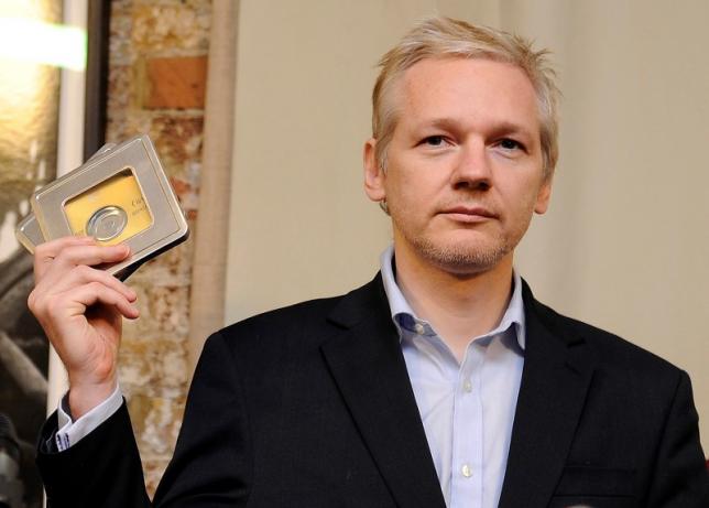 WikiLeaks founder Julian Assange holds up CD's containing data on offshore bank account holders, which he received from former Swiss private banker Rudolf Elmer at the Frontline club in London, Britain, January 17, 2011. REUTERS/Paul Hackett/Files