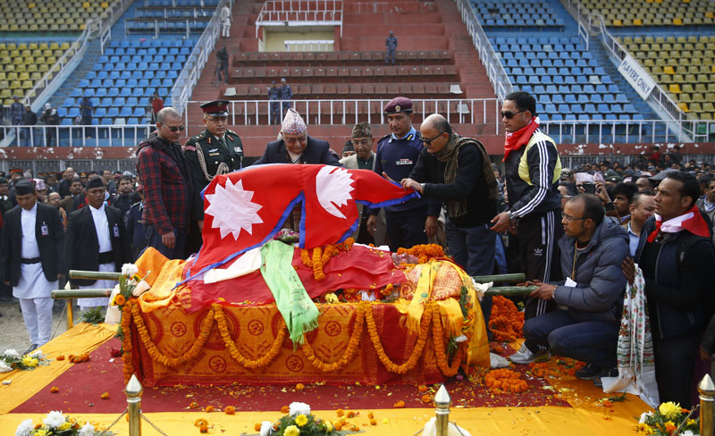 Prime Minister KP Sharma Oli drapes the national flag over the body of late Sushil Koirala, in Kathmandu, on Tuesday, February 9, 2016. Photo: Skanda Gautam