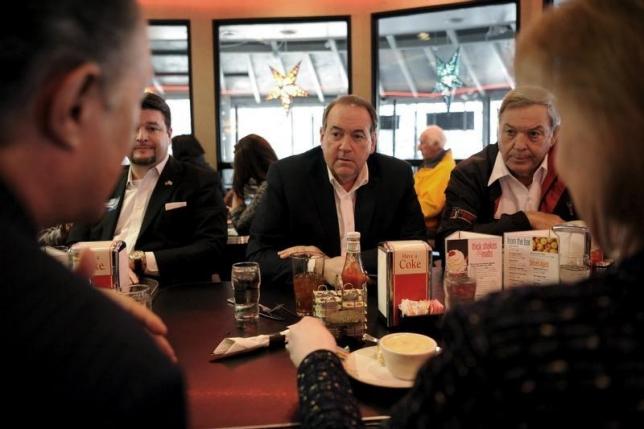 U.S. Republican presidential candidate Mike Huckabee (C) eats lunch with supporters, including former Congressman Duncan Hunter (R), at Drake Diner in Des Moines, Iowa February 1, 2016. REUTERS/Mark Kauzlarich