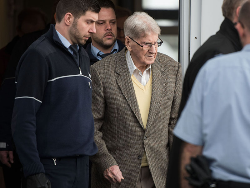 94-year-old former SS guard at the Auschwitz death camp Reinhold Hanning (centre) leaves the building after the opening of his trial in Detmold, Germany, on Thursday, February 11, 2016.Photo: Bernd Thissen/Pool Photo via AP