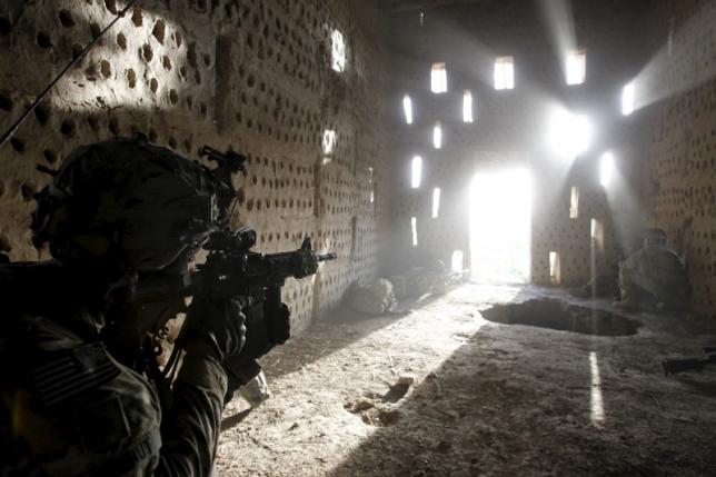 U.S. soldier Nicholas Dickhut from 5-20 infantry Regiment attached to 82nd Airborne points his rifle at a doorway after coming under fire by the Taliban while on patrol in Zharay district in Kandahar province, southern Afghanistan in this April 26, 2012 file photo. REUTERS/Baz Ratner/Files