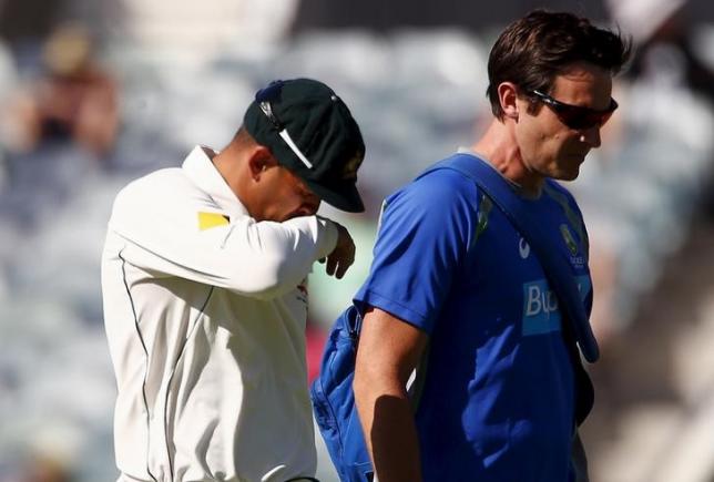 Australia's Usman Khawaja (L) reacts as he walks off the ground with a team trainer after suffering an injury during the second day of the second cricket test match against New Zealand at the WACA ground in Perth, Western Australia, November 14, 2015. REUTERS/David Gray/files