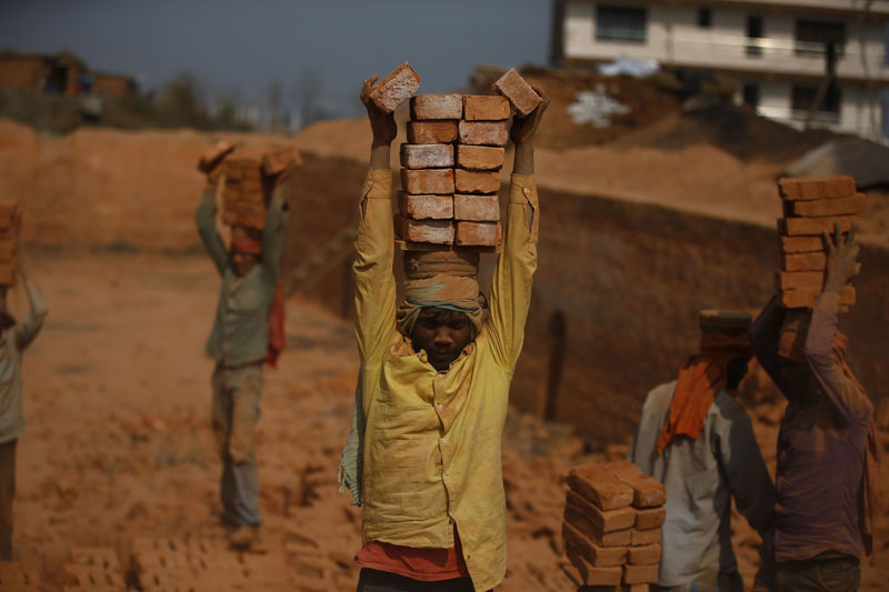 Migrant workers balance bricks on their heads at a brick kiln in Sipadol, Bhaktapur on Wednesday, February 3, 2016. Photo: Skanda Gautam