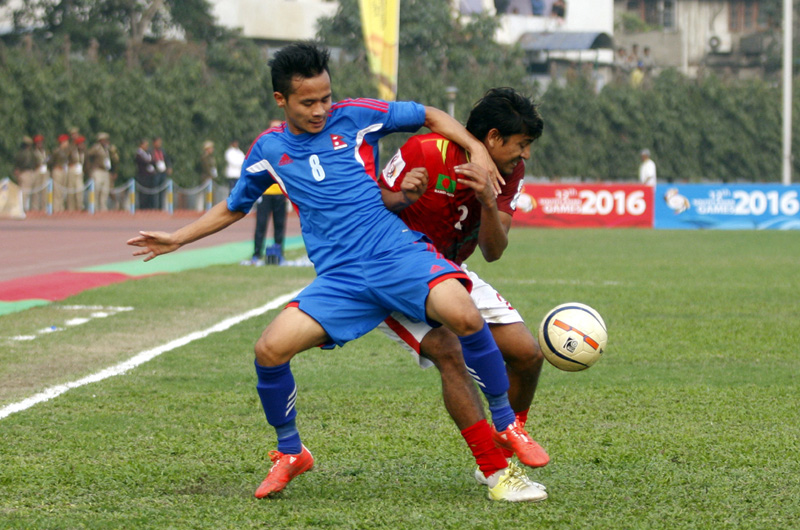 Nepal's Bishal Rai (left) vies for the ball with a Bangladeshi player during their menu0092s football match in the 12th SA Games, on Thursday. Photo: PJ Club