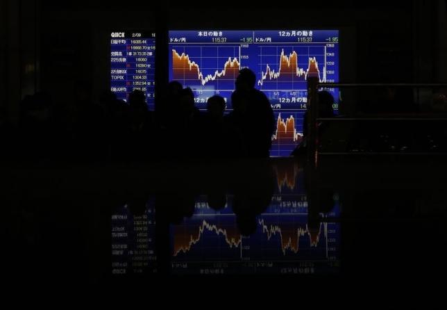 Pedestrians walk past an electronic board showing the graphs of the recent fluctuations of the Japanese yen's exchange rate against the U.S. dollar outside a brokerage in Tokyo, Japan, February 9, 2016. REUTERS/Yuya Shino