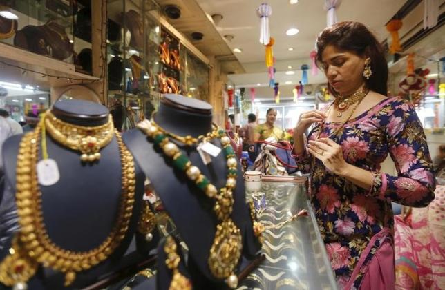 A customer tries a gold necklace at a jewellery showroom at a market in Mumbai, India, November 9, 2015. REUTERS/Shailesh Andrade/Files