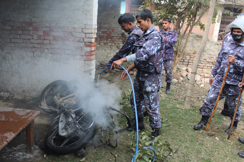 Police attempt to douse the fire in two motorcycles belonging to Nepali Congress leader Bimalendra Nidhi's family in Janakpurdham on Monday, February 1, 2016. Photo: Brij Kumar Yadav