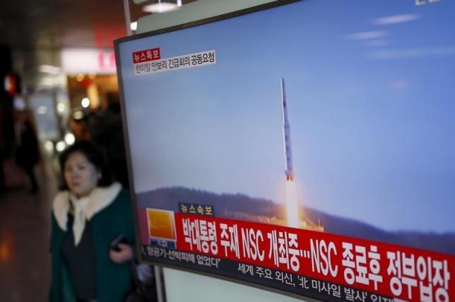 A passenger walks past a TV screen broadcasting a news report on North Korea's long range rocket launch at a railway station in Seoul, South Korea, February 7, 2016.   REUTERS/Kim Hong-Ji