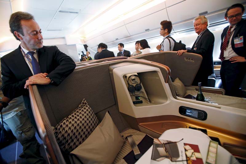 Fabrice Bregier (left), President and CEO of Airbus, looks at a business class seat during a tour of the first of 67 new Airbus A350-900 planes delivered to Singapore Airlines at Singapore's Changi Airport on March 3, 2016. Photo: Reuters