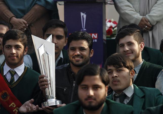 Pakistan's ODI's team captain Azhar Ali (C) holds World Twenty20 trophy as he poses for a picture with the students of Army Public School (APS) during a ceremony at a school in Peshawar, Pakistan, January 11, 2016. REUTERS/Fayaz Aziz