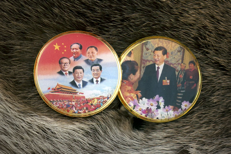 A National People's Congress (NPC) delegate from Tibet wears pins depicting five current and former Chinese leaders (left) and Chinese President Xi Jinping (right) as he leaves the Great Hall of the People following the opening session of the NPC in Beijing, on Saturday, March 5, 2016. Photo: AP