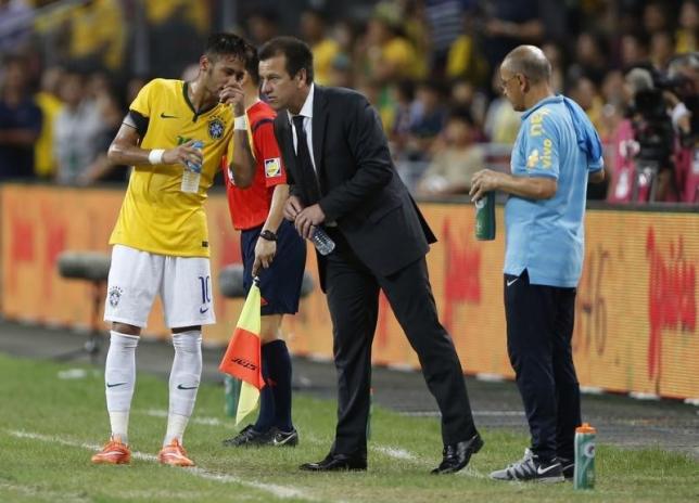 Brazil's Neymar speaks to his coach Dunga during their soccer friendly match against Japan at the national stadium in Singapore October 14, 2014. REUTERS/Xavier Galiana