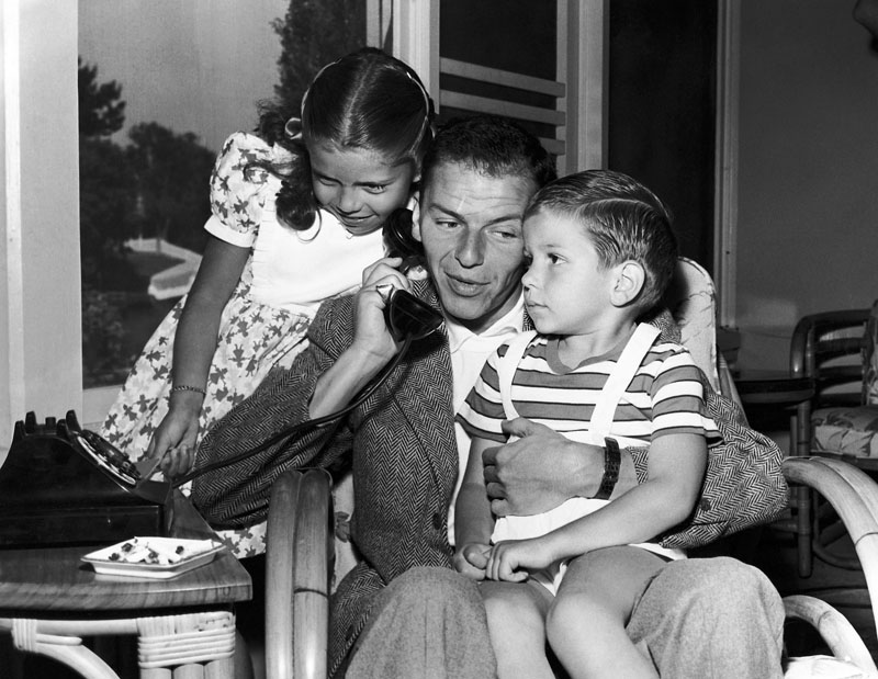 Frank Sinatra holds a telephone with his children, Nancy and Frank Jr, in the Hollywood area of Los Angeles, in 1948. Photo: AP