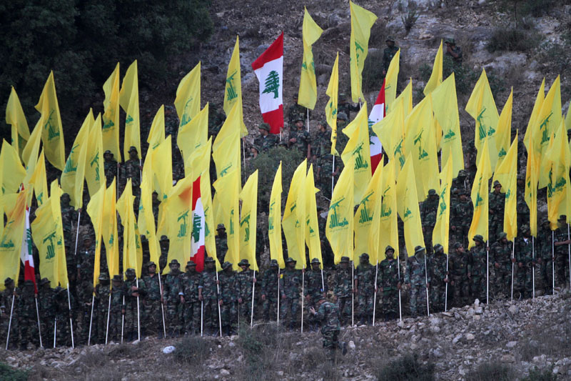 FILE - Hezbollah fighters hold their group and Lebanese flags, as they perform during a rally marking the ninth anniversary of the 2006 Israel-Hezbollah war, at the southern Lebanese village of Wadi al-Hujair, Lebanon, on August 14, 2015. Photo: AP