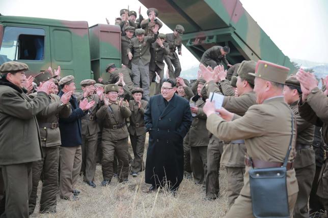 North Korean leader Kim Jong Un (C) smiles as he guides a test fire of a new multiple launch rocket system in this undated photo released by North Korea's Korean Central News Agency (KCNA) in Pyongyang March 4, 2016.    REUTERS/KCNA