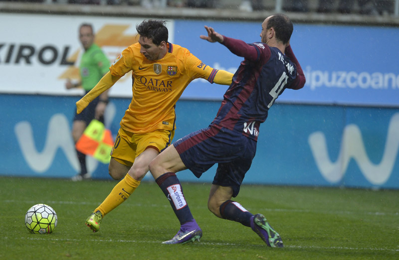 Barcelona's Lionel Messi (left) and  Eibar's Iban Ramis Barrios vie for the ball during their Spanish League match at the Ipurua Stadium in Eibar on Sunday. Photo: Reuters