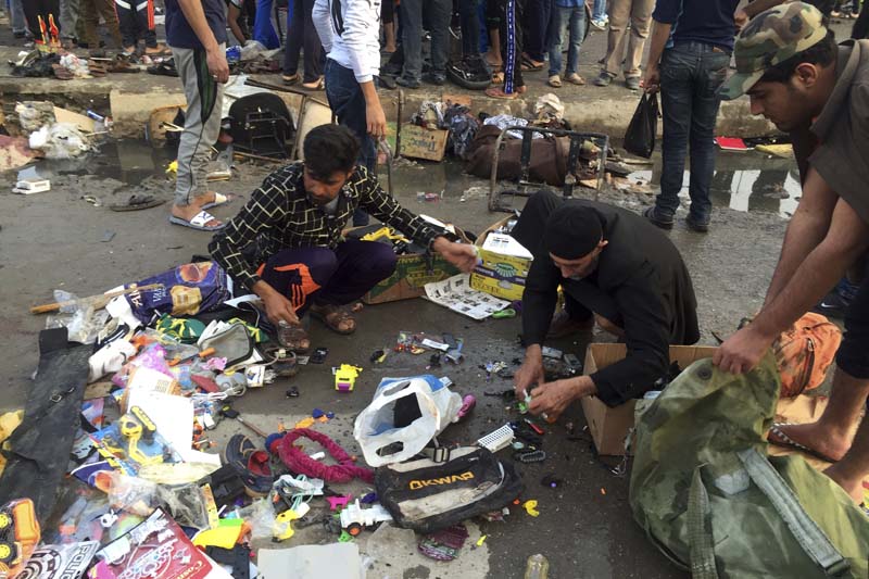 Street vendors collect their belongings after deadly bombing attacks in Sadr City, Baghdad, Iraq on Sunday, February 28, 2016. Photo: AP