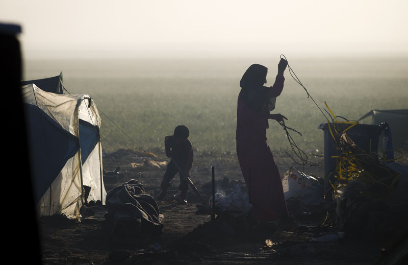 A migrant woman prepares to hang laundry to dry at the northern Greek border point of Idomeni, Greece, on Saturday, March 19, 2016. Photo: AP