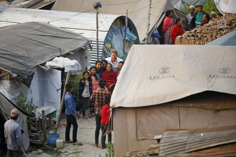 Prince Harry (centre) takes a photo with earthquake survivors, residing in makeshift tents after they were displaced by the earthquakes that occurred last year, in Byasi, Bhaktapur, on Sunday, March 20, 2016. Photo: Skanda Gautam/ THT