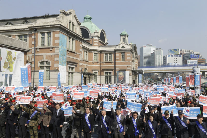 South Korean war veterans hold up their cards during a rally denouncing North Korea's recent threat in Seoul, South Korea, on Friday, March 25, 2016. Photo: AP