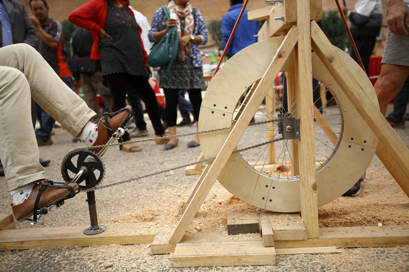 A woman peddles a woodwork cycle made by a Chinese artist during the week-long wood art festival in Kathmandu, on Thursday, March 24, 2016.  Photo: Skanda Gautam