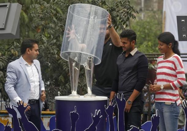 A cricket fan removes a glass cover displaying the men's and women's World Twenty20 trophies after they arrived in Kolkata, February 24, 2016. REUTERS/Rupak De Chowdhuri/Files