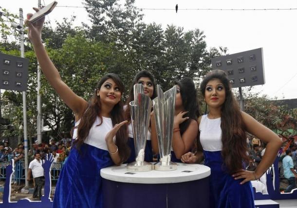 Models take a selfie next to the World Twenty20 trophies after they arrived in Kolkata, India, February 24, 2016. REUTERS/Rupak De Chowdhuri/Files