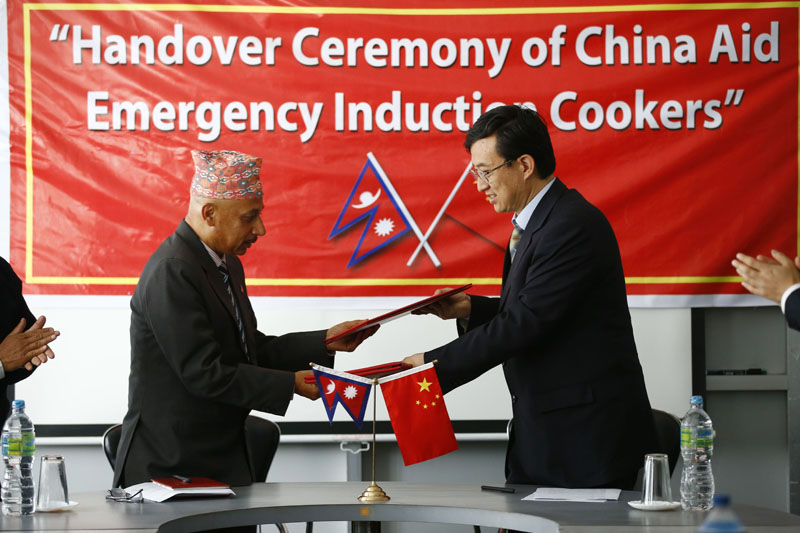 Chinese Ambassador Wu Chuntai (right) shaking hands with Secretary at the Ministry of Supplies Shreedhar Sapkota after handing over 10,000 ninduction heaters to Nepal government, in Kathmandu, on Wednesday. THT