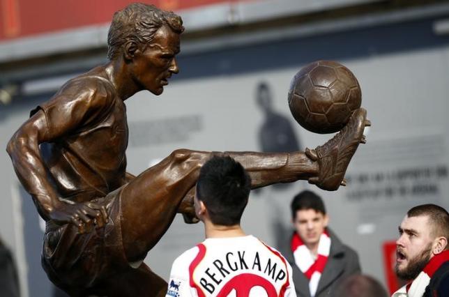 Arsenal fans look at a statue of former striker Dennis Bergkamp after it was unveiled before their English Premier League soccer match against Sunderland at the Emirates Stadium in London, February 22, 2014.   REUTERS/Darren Staples