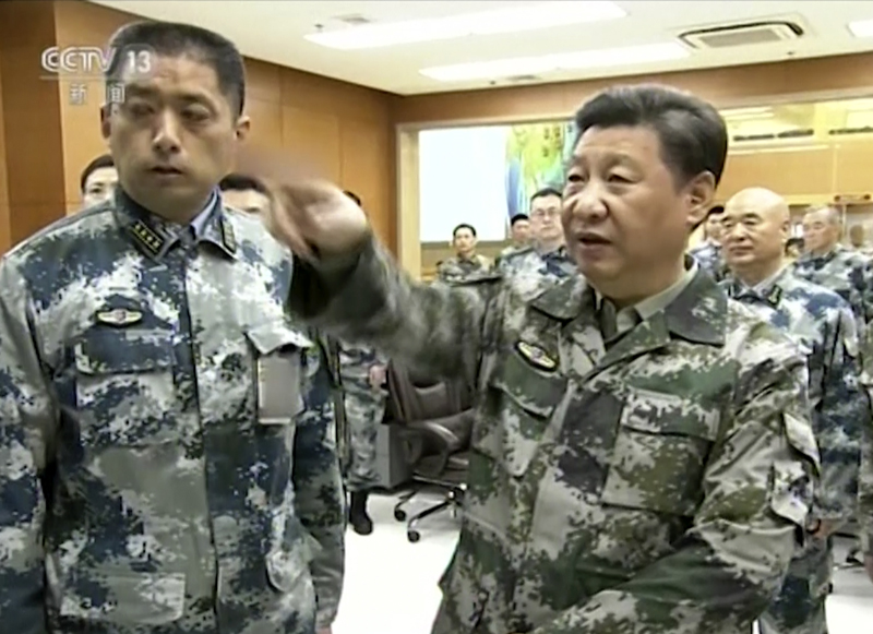 Chinese President Xi Jinping (right) in military uniform gestures as he tours to the Chinese armyu0092s Joint Operation Command Centre in Beijing, on Thursday, April 21, 2016. Photo: video footage from CCTV via AP Video