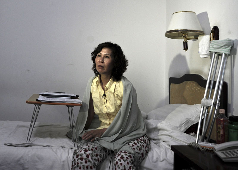 FILE - Chinese lawyer Ni Yulan sits on a bed in a hotel in Beijing. Ni was awarded the State Department's International Women of Courage Award for her work defending people forcibly evicted from their homes, on June 30, 2010. Photo: Andy Wong/AP