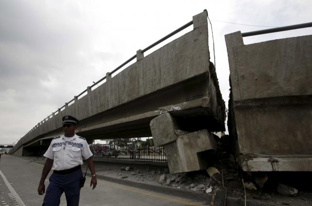 An officer walks beside a collapsed bridge after an earthquake struck off the Pacific coast, in Guayaquil, Ecuador, April 17, 2016. REUTERS/Henry Romero