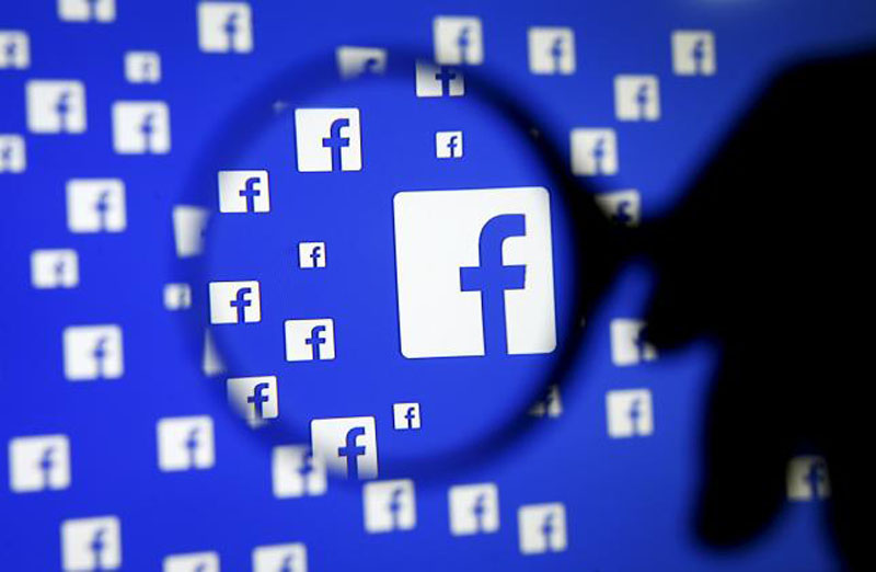 A man poses with a magnifier in front of a Facebook logo on display in this illustration taken in Sarajevo, Bosnia and Herzegovina, in this December 16, 2015, file photo. Photo: Reuters