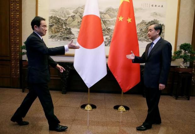 Japanese Foreign Minister Fumio Kishida ( L) and China's Foreign Minister Wang Yi reach out to shake hands during a meeting at Diaoyutai State Guesthouse, in Beijing, China, April 30, 2016. REUTERS/Jason Lee