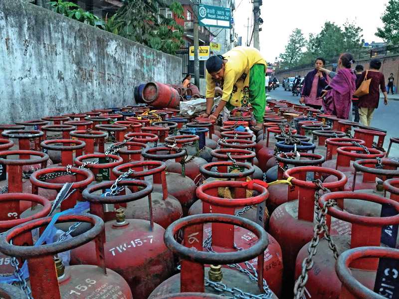 FILE- A woman looking for her cylinder among the ones queued up for refilling near a gas depot, in Kathmandu, in April 2016. Photo: Skanda Gautam/THT