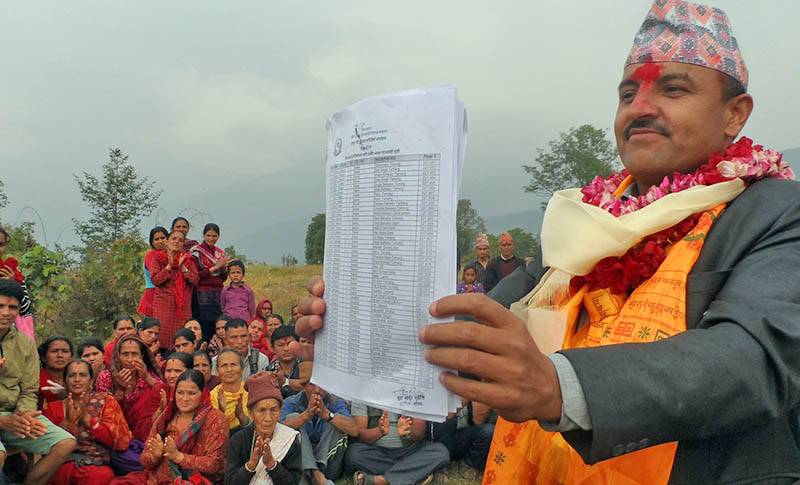 Chief District Officer Narayan Bhatta shows the list of earthquake victims, who are eligible to get the grant for house reconstruction, at Hansapur VDC of Gorkha district. Photo: RSS