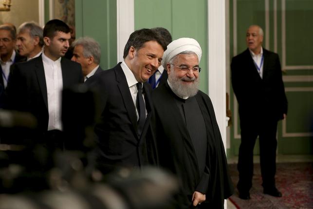 Iran's President Hassan Rouhani walks with Italian Prime Minister Matteo Renzi (L) as they arrive to attend a ceremony to sign deals in Tehran, Iran, April 12, 2016. REUTERS/President.ir/Handout