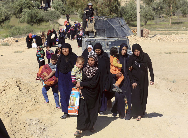 Elite counter terrorism forces escorting people flee their homes during clashes between Iraqi security forces and Islamic State group in Hit, 85 miles (140 kilometres) west of Baghdad, Iraq, Monday, April 4, 2016. Photo: AP