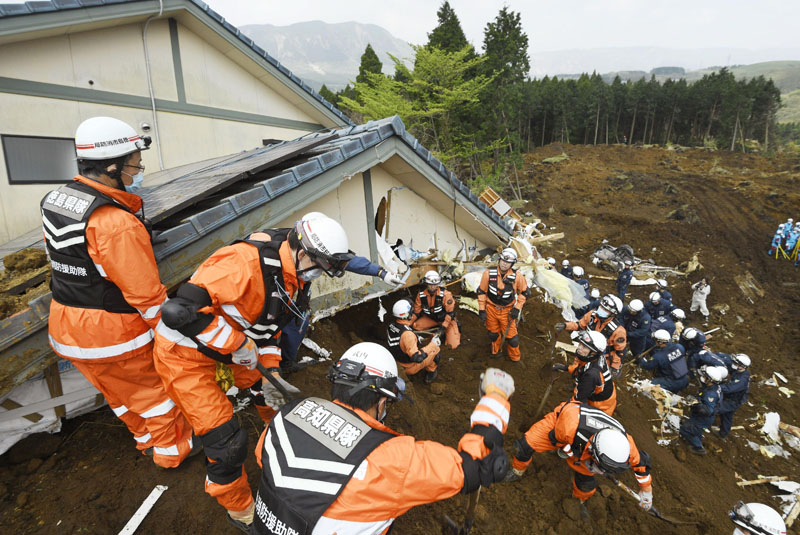 Rescuers search for missing persons at the site of a landslide in Minamiaso, Kumamoto prefecture, Japan, on Tuesday, April 19, 2016. Photo: Yohei Fukai/Kyodo News via AP