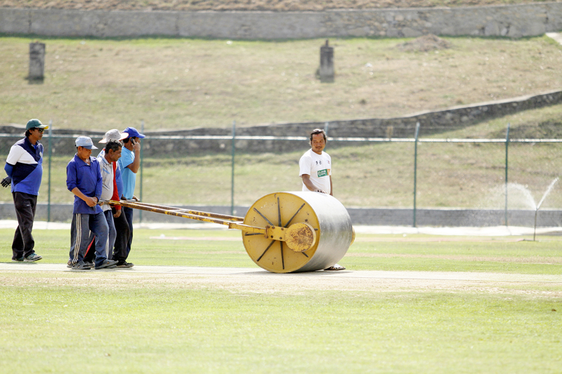 Workers push a roller to maintain a cricket pitch at the Kirtipur-based cricket ground on Thursday, April 7, 2016. Photo: RSS