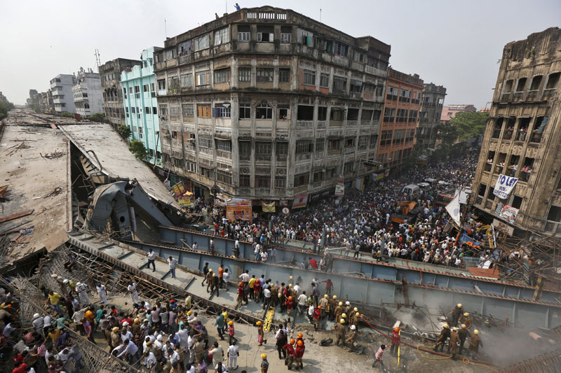 Firefighters and rescue workers search for victims at the site of an under-construction flyover after it collapsed in Kolkata, India, on Thursday, March 31, 2016. Photo: Reuters